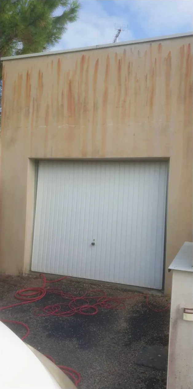 Façade de garage présentant des traces avant intervention — photo transmise par Sosson Rénovation